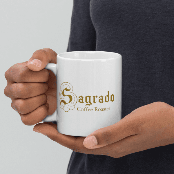 a person holding a Sagrado Coffee white 110z mug 2